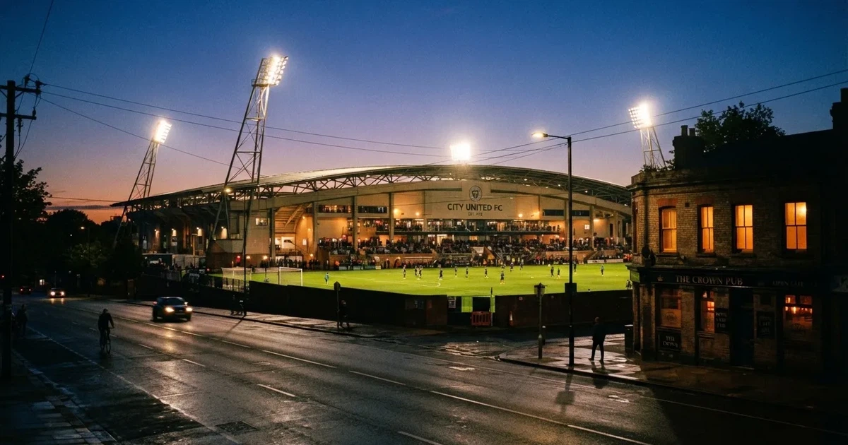 Ein Fußballstadion bei Flutlicht aus der Ferne gesehen, davor eine Straße und leuchtende Fenster eines Nebengebäudes.